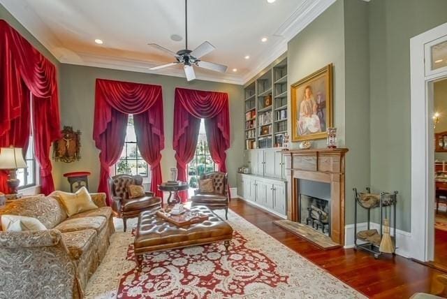 sitting room featuring dark hardwood / wood-style floors, ceiling fan, built in features, and ornamental molding