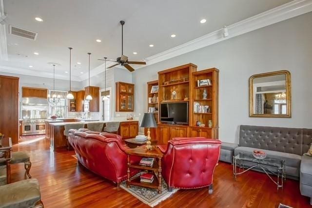 living room featuring ceiling fan, crown molding, and hardwood / wood-style flooring