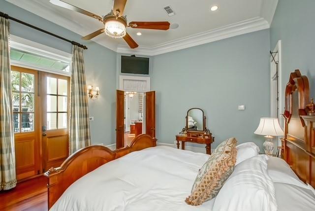 bedroom featuring ceiling fan, crown molding, and hardwood / wood-style flooring