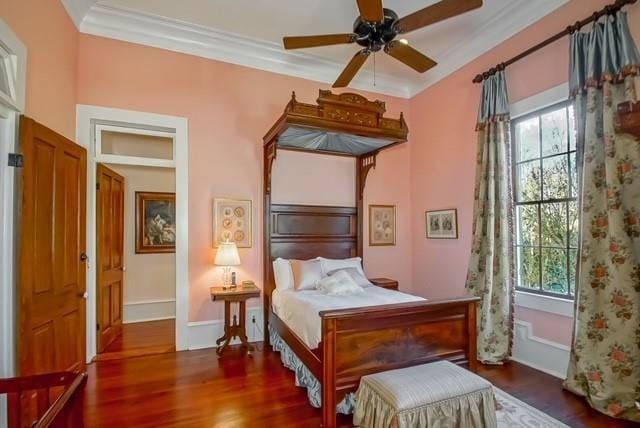 bedroom with crown molding, ceiling fan, dark hardwood / wood-style floors, and multiple windows