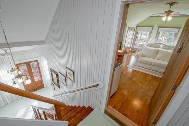 stairway featuring hardwood / wood-style floors, ceiling fan, and high vaulted ceiling