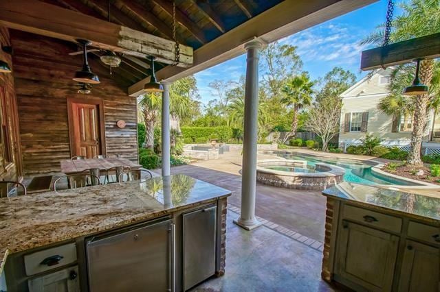 view of terrace with a pool with hot tub