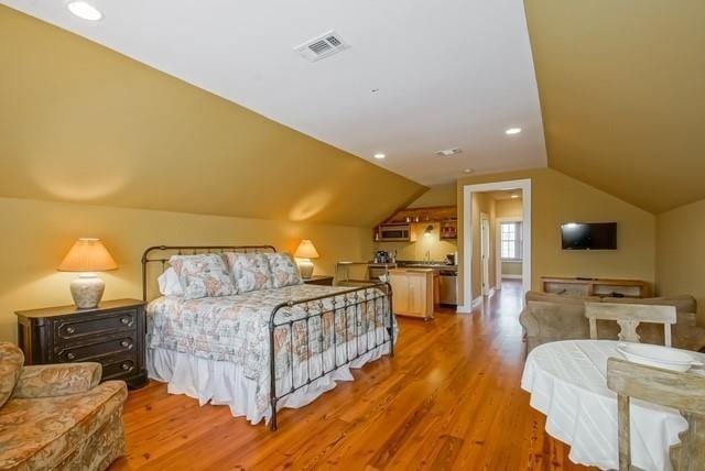 bedroom with wood-type flooring and lofted ceiling