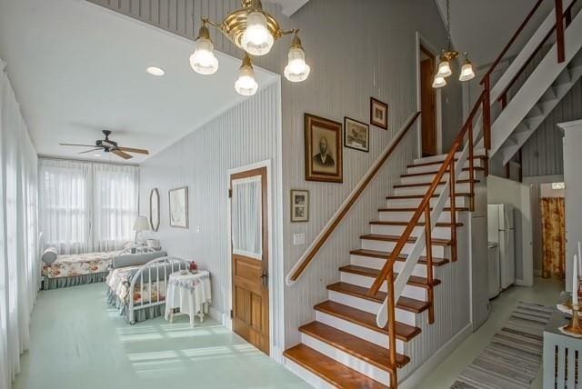 stairway with ceiling fan with notable chandelier