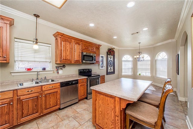 kitchen featuring decorative light fixtures, appliances with stainless steel finishes, a notable chandelier, a center island, and sink