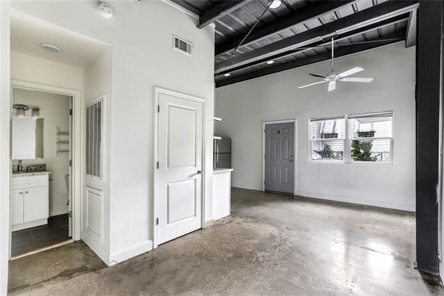 interior space featuring a high ceiling and ensuite bath