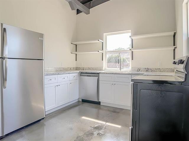 kitchen featuring a high ceiling, white cabinetry, sink, stainless steel appliances, and washer / clothes dryer