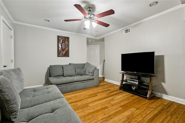 living room featuring ornamental molding, ceiling fan, and light wood-type flooring