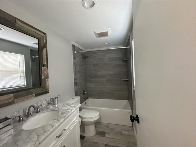 full bathroom featuring tiled shower / bath combo, hardwood / wood-style flooring, toilet, and vanity