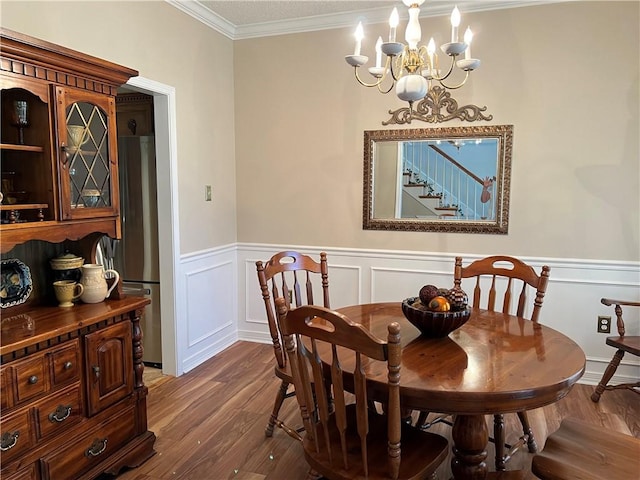 dining space featuring crown molding, dark hardwood / wood-style flooring, and a chandelier