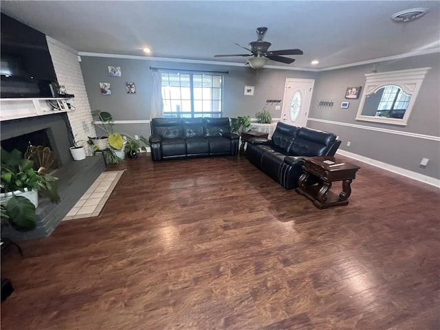 living room featuring dark hardwood / wood-style floors, ceiling fan, a fireplace, brick wall, and ornamental molding