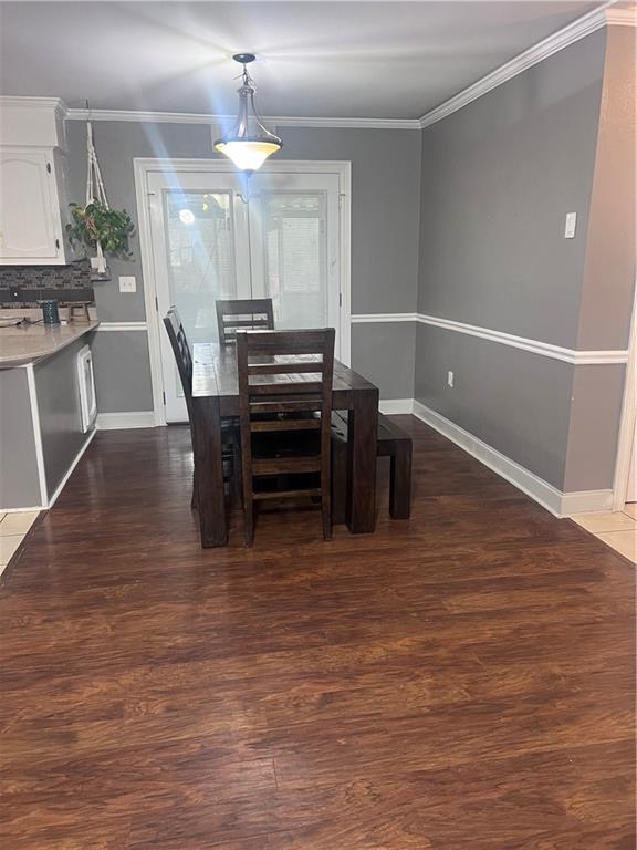 dining space with dark hardwood / wood-style floors and crown molding