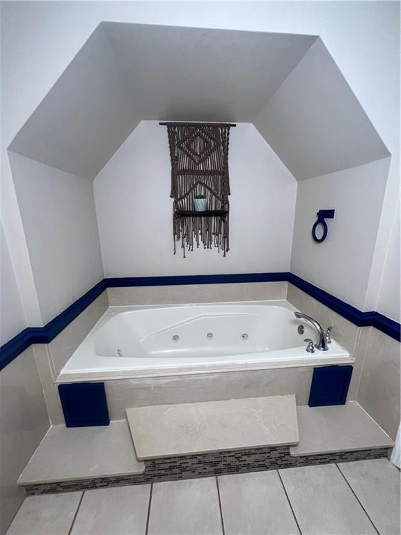 bathroom featuring tiled bath and tile floors