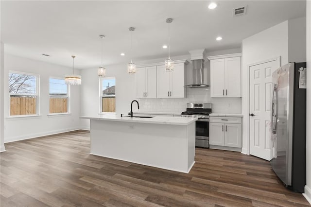 kitchen featuring wall chimney range hood, dark hardwood / wood-style floors, white cabinets, and appliances with stainless steel finishes