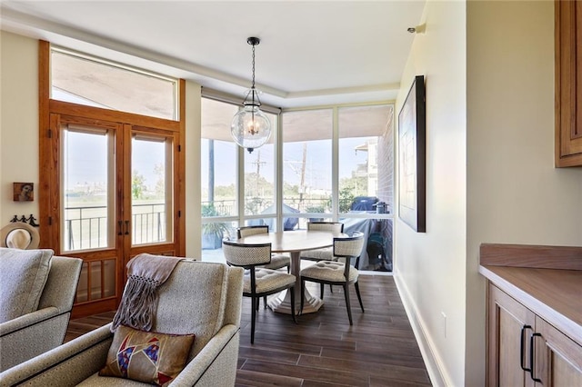 dining space with floor to ceiling windows, plenty of natural light, and dark hardwood / wood-style floors