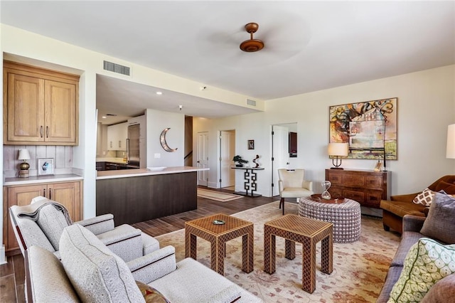 living room with ceiling fan and dark hardwood / wood-style floors