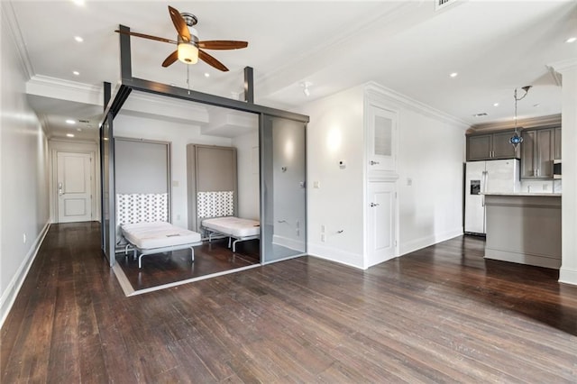 interior space featuring dark wood-type flooring, ornamental molding, and ceiling fan