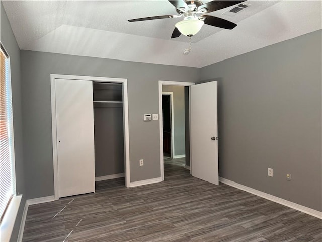 unfurnished bedroom with a closet, lofted ceiling, dark hardwood / wood-style floors, and ceiling fan