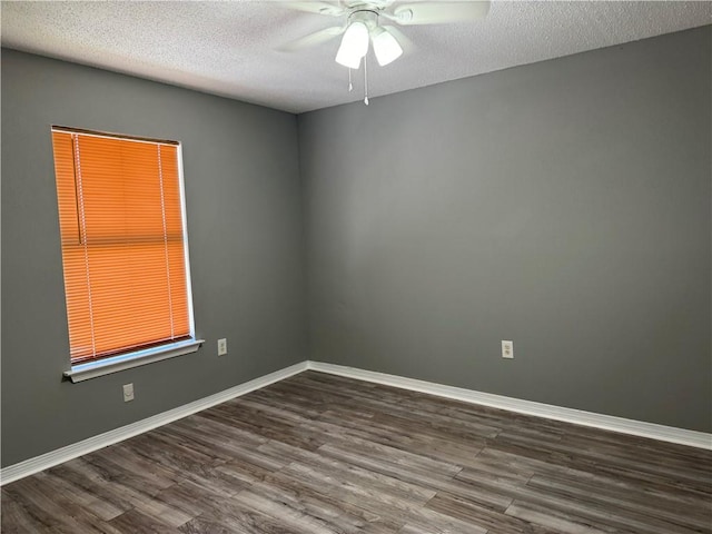 empty room featuring ceiling fan, dark hardwood / wood-style floors, and a textured ceiling