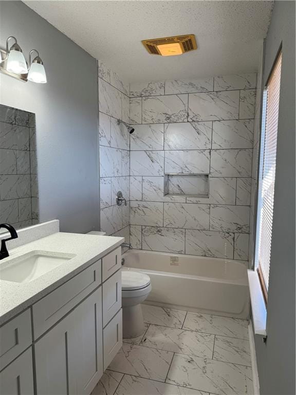 full bathroom featuring tile floors, tiled shower / bath combo, vanity, and a wealth of natural light