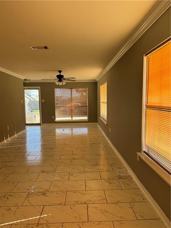 tiled empty room featuring a textured ceiling, ceiling fan, and ornamental molding