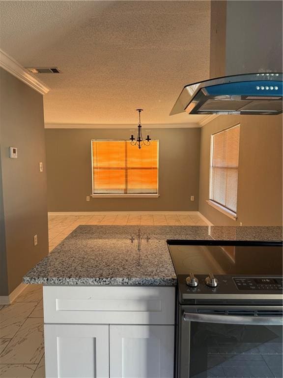 kitchen with range, dark stone countertops, white cabinets, island range hood, and ornamental molding