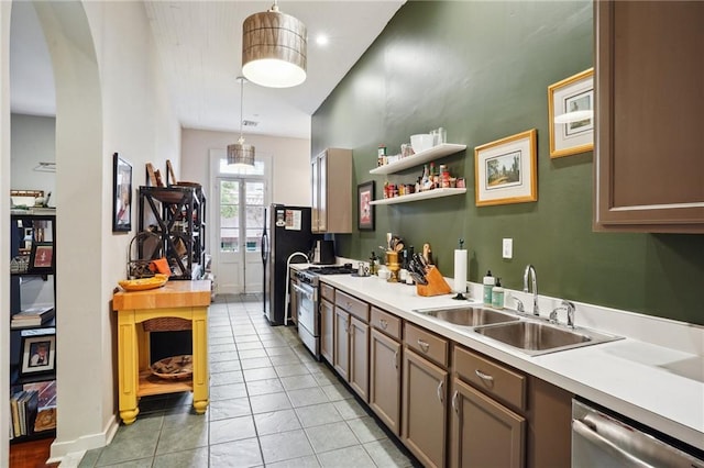 kitchen featuring appliances with stainless steel finishes, pendant lighting, sink, and light tile floors