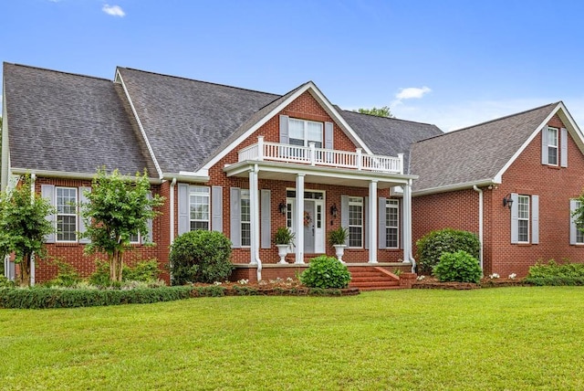 view of front of house with a porch, a front lawn, and a balcony