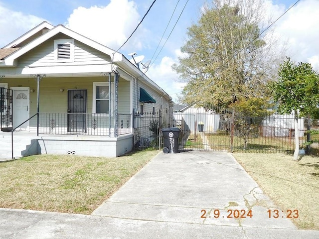 bungalow-style house featuring covered porch and a front yard