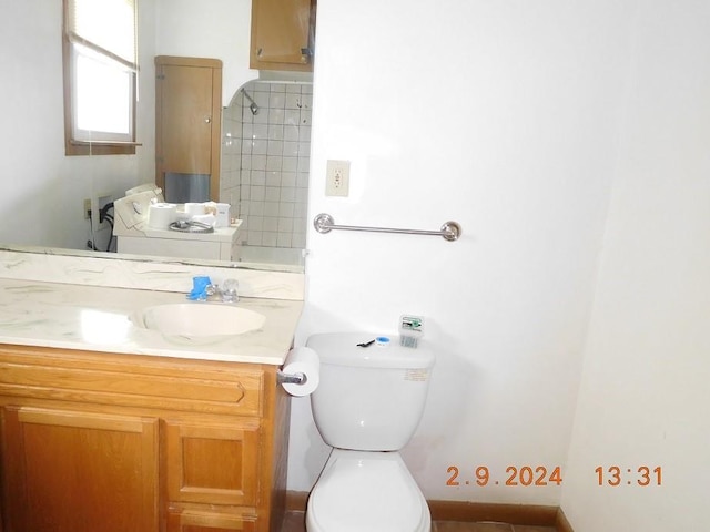 bathroom with toilet and vanity with extensive cabinet space