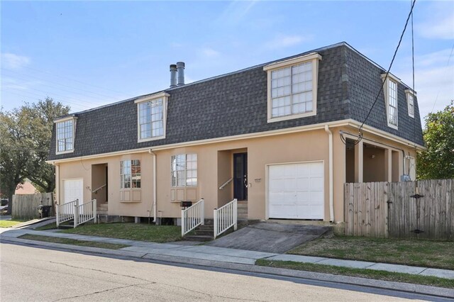 view of front of property with a garage and a front lawn