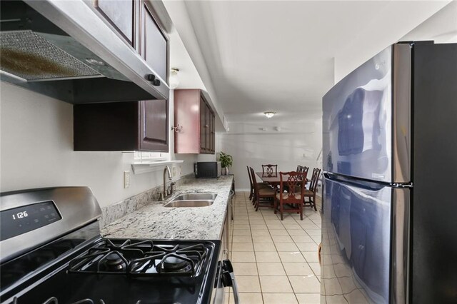 kitchen with appliances with stainless steel finishes, sink, and light tile patterned floors