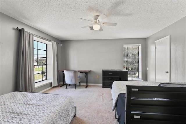 bedroom featuring ceiling fan, a textured ceiling, and multiple windows