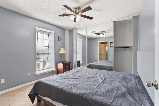 carpeted bedroom with a closet, a textured ceiling, and ceiling fan