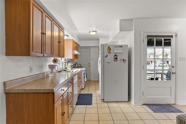 kitchen with light tile patterned flooring, white appliances, and exhaust hood