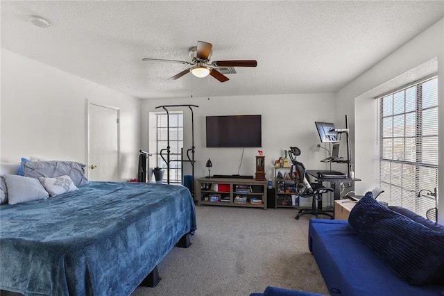 bedroom with carpet floors, a textured ceiling, and ceiling fan