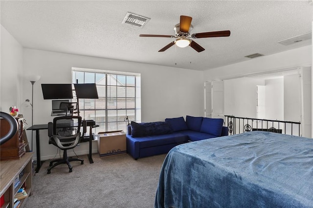 carpeted bedroom featuring ceiling fan and a textured ceiling