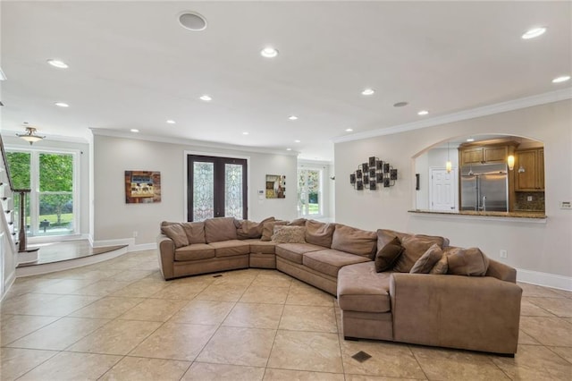 tiled living room with ornamental molding and french doors