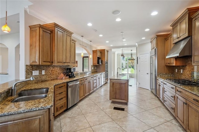 kitchen featuring sink, hanging light fixtures, stainless steel appliances, ornamental molding, and light stone countertops