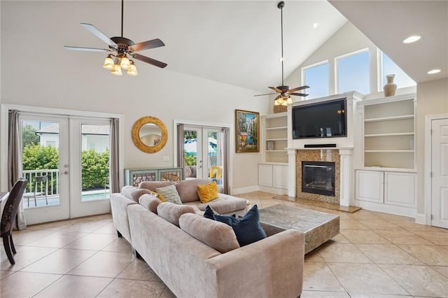 living room featuring ceiling fan, light tile patterned floors, a fireplace, and french doors