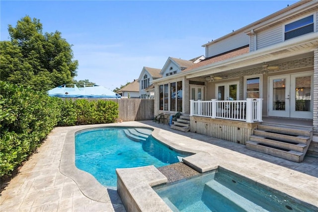 view of pool with a patio, french doors, and an in ground hot tub