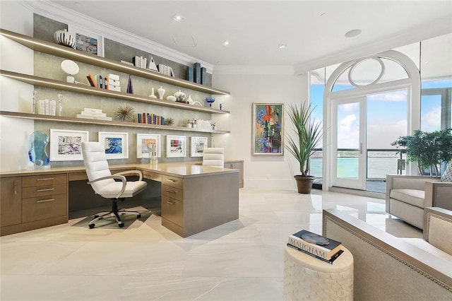 office area featuring built in desk, a water view, light tile floors, and crown molding