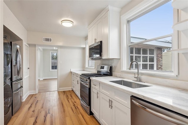 kitchen featuring white cabinets, stainless steel appliances, light hardwood / wood-style flooring, and sink