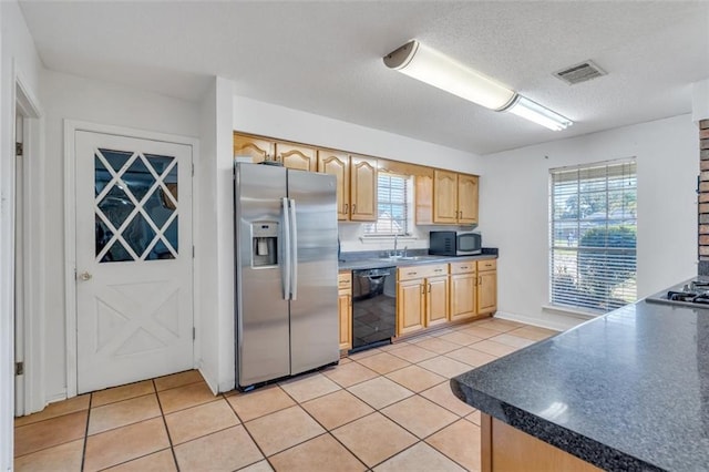 kitchen with sink, appliances with stainless steel finishes, light tile floors, and a wealth of natural light