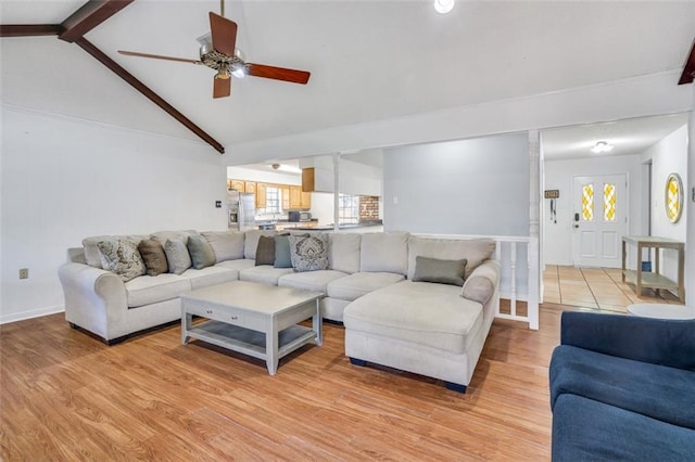 living room featuring light hardwood / wood-style floors, ceiling fan, high vaulted ceiling, and beam ceiling