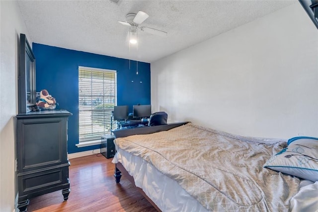 bedroom featuring pool table, a textured ceiling, ceiling fan, and dark wood-type flooring