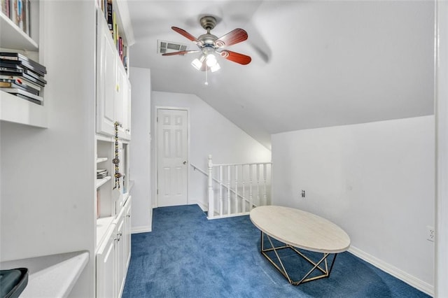 interior space featuring vaulted ceiling, ceiling fan, and dark colored carpet