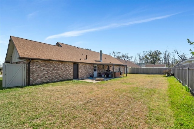 back of house with a patio, a hot tub, and a yard