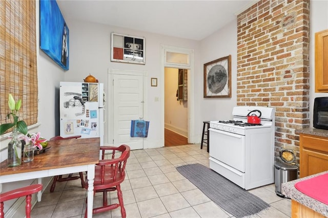 interior space with white gas range, blue cabinets, and light tile floors