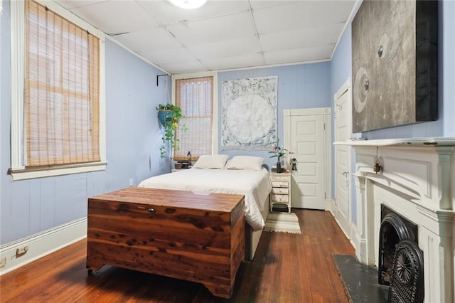 bedroom with a paneled ceiling and dark hardwood / wood-style floors